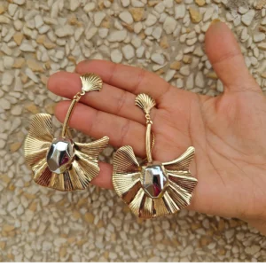 Metal Golden Earrings-Long Butterfly Danglers displayed on palm