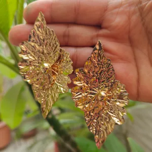 Golden Earrings Leaf Design-Large Broad Earrings displayed on palm