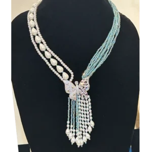 Aqua Blue Necklace in tassel with white shell pearls, displayed on a black stand