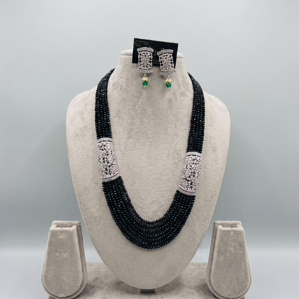 Green Layered Necklace Set with Pink earrings displayed on an off white jewellery stand