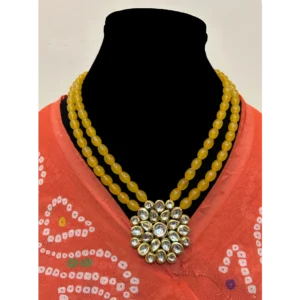 Yellow Layered Necklace Kundan Pendant displayed on a black colour stand making with orange colour saree wrapped on stand to make a neckline
