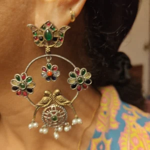 large golden hoop earrings with multicolour stones, a woman wearing it