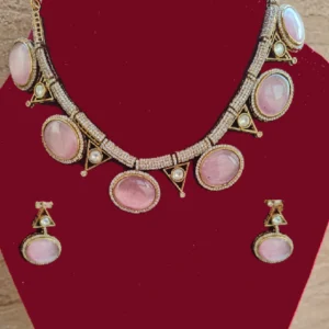 pink collar necklace set in fine stone, displayed on a red colour jewellery stand