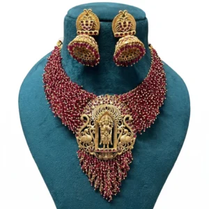 ruby colour beaded necklace set displayed on a blue jewellery stand