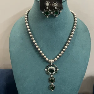 Emerald Green Pendant Pearl Necklace Set In Grey displayed on a mannequin