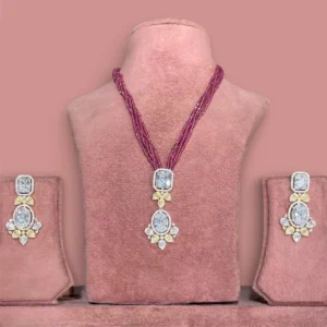 Ruby pink beaded jewellery set with large diamond-style pendant and matching earrings on pink display stand