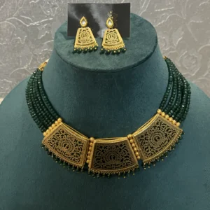Green Choker Set Golden Pendant displayed on a green colour stand