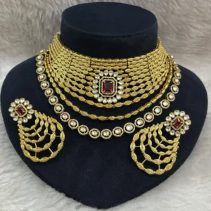 Golden Kundan Bridal Jewellery Set with Ruby Stone displayed on a black colour jewellery stand