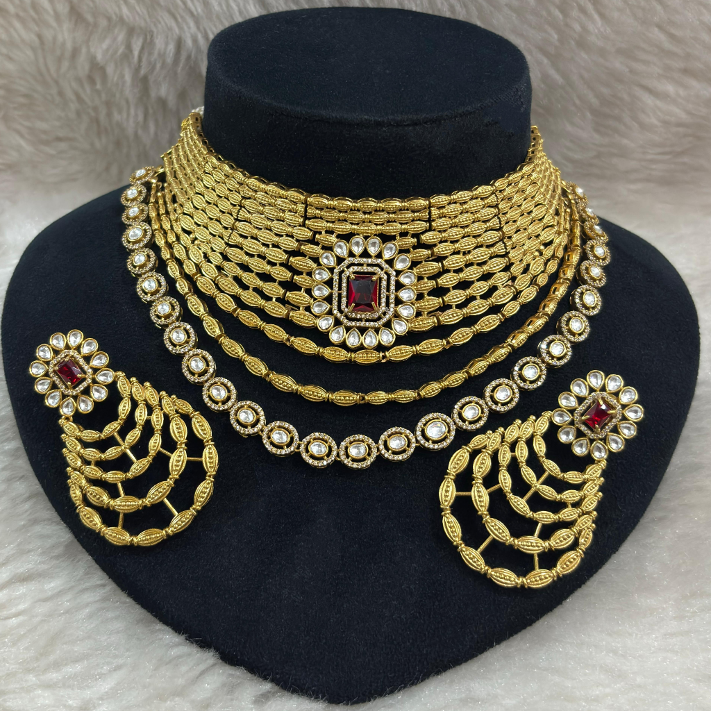 Golden Kundan Bridal Jewellery Set 1 Golden Kundan Bridal Jewellery Set with Ruby Stone displayed on a black colour jewellery stand