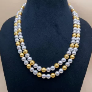 Two Tone Pearl Necklace in Gold and White Colour displayed on a black jewellery stand